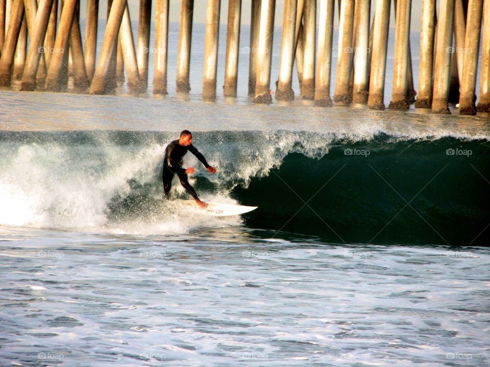 Surf On!. Surfer riding a wave in Huntington Beach, California