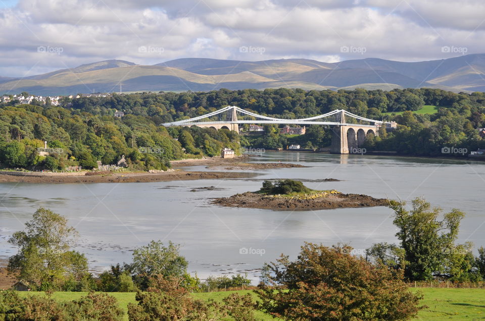 Thomas Telford Suspension Bridge over the Menai Straits, Anglesey, Wales, UK with Snowdonia in the background.