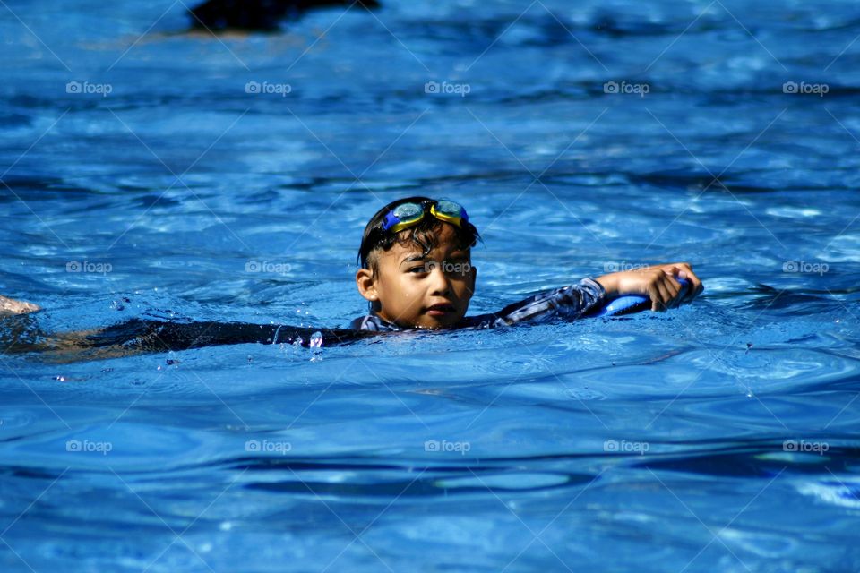 young kid swimming in a swimming pool