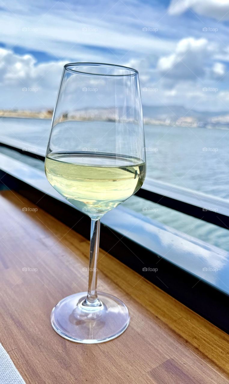 Бокал белого вина, море и горы 