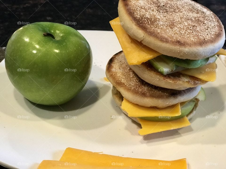 An apple and cheese melt sandwich displayed on a white plate in the kitchen. USA, America 