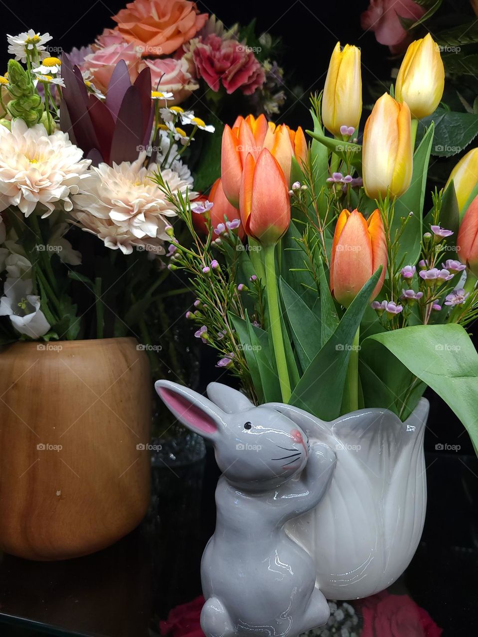 Beautiful spring flowers in various vases and vessels celebrating spring and Easter, with tulips, roses and the like