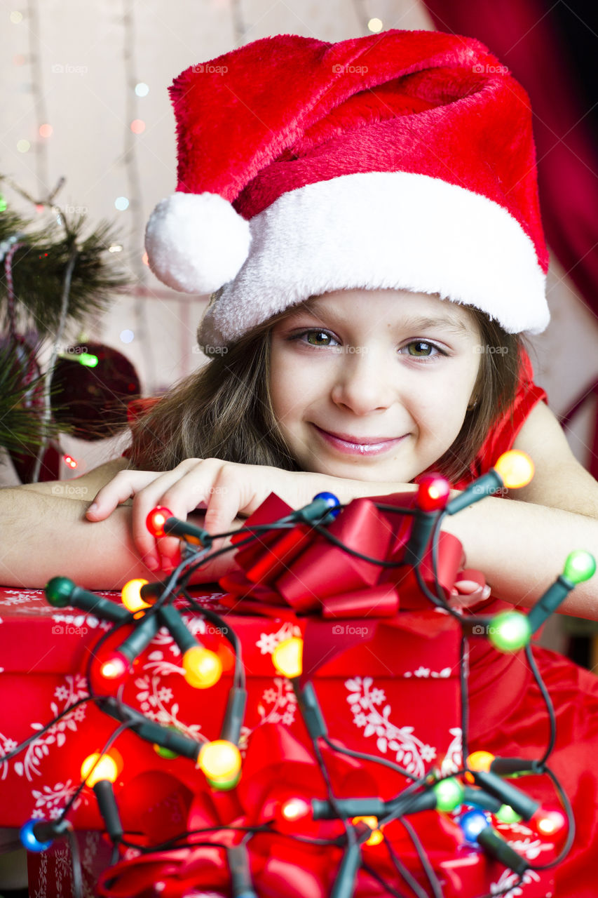 Cute smiling girl wearing santa claus hat