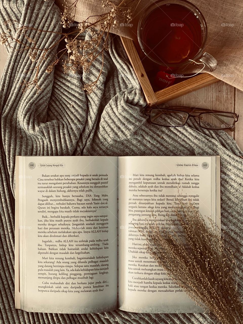 Flat lay of autumn photography. A novel that opens, a cup of tea and autumn clothes.