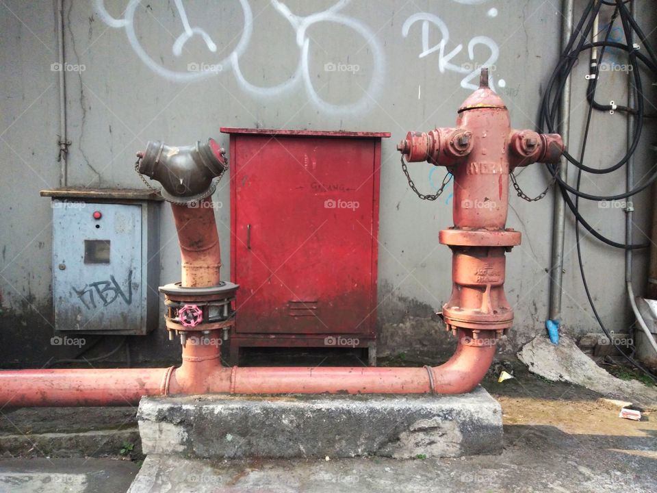 Red Electrical panel behind the hydrant pipe