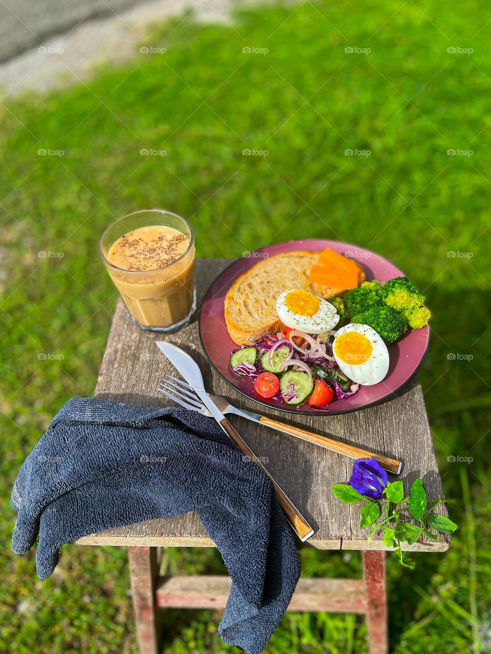 Outdoor breakfast. Healthy meal with toast, egg and veggies. A cup of hot milky coffee 