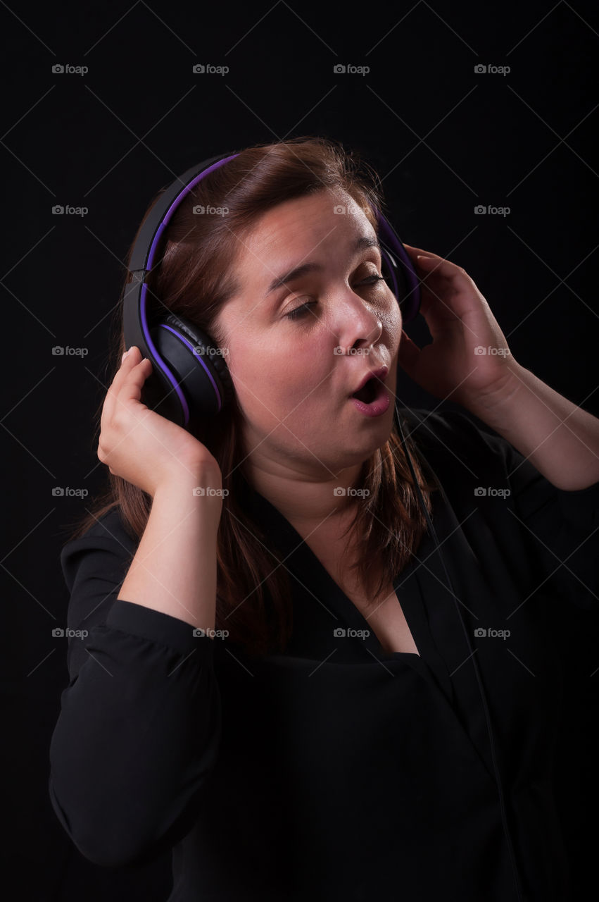 Woman with headphones singing.