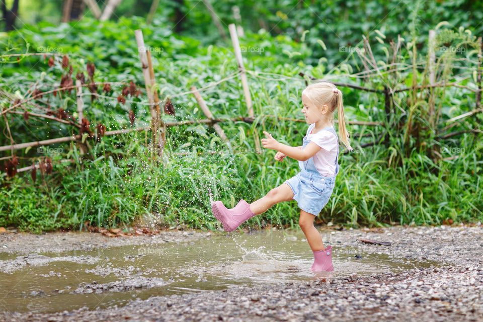 Happy kid having fun in puddle 