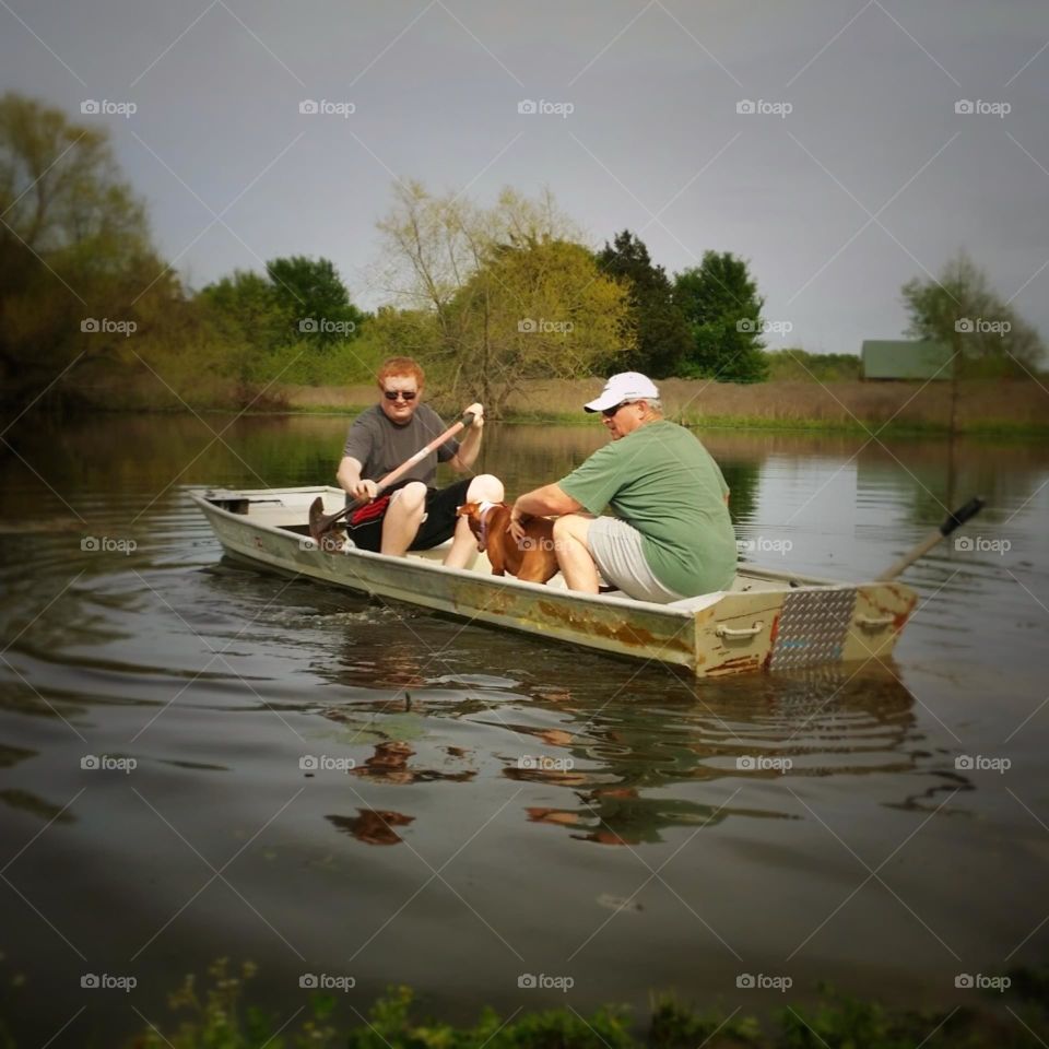 Two Men in an Old Boat with a Dog Using a shovel for an oar 😁