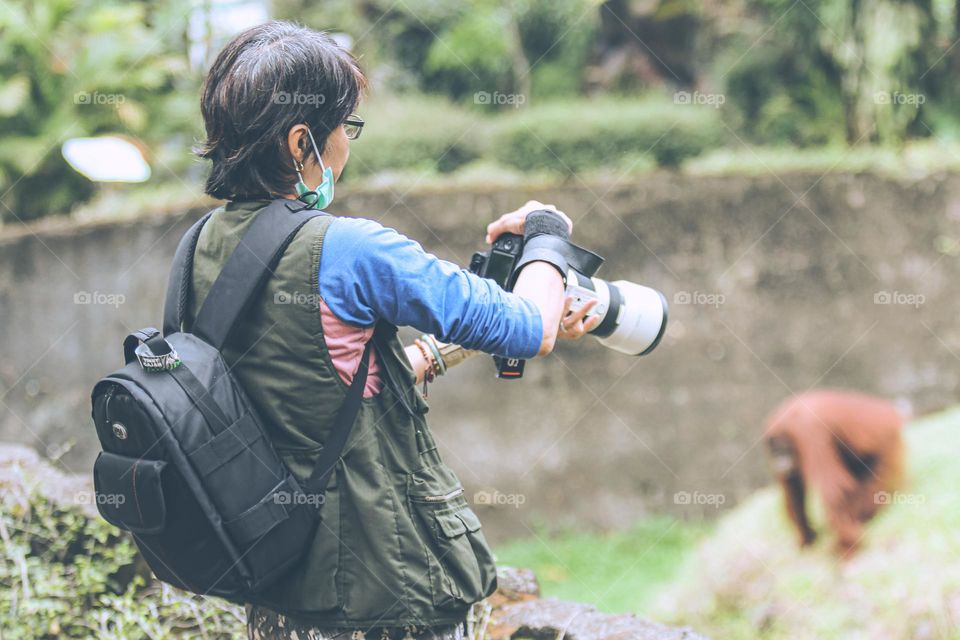 a woman taking a picture of an animal using her camera