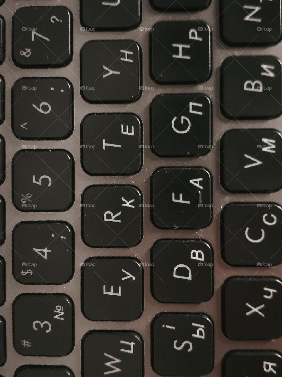 A macro photo of a gray laptop keyboard with an English layout