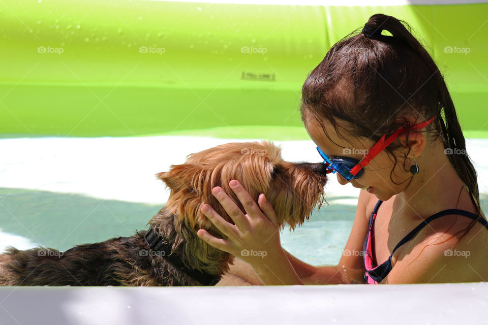 Child and her best friend in a blowup pool