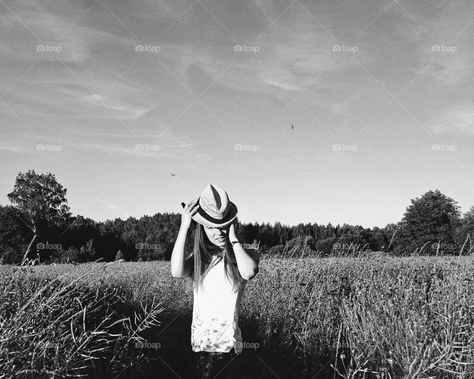 Young woman wearing hat standing in field