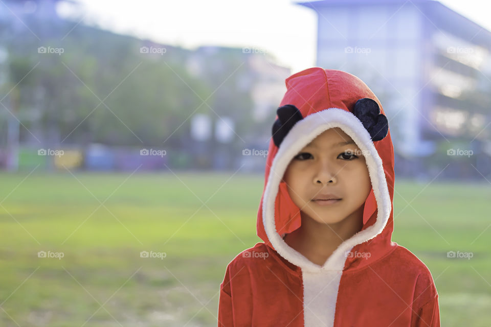 Asia boy wearing a red Christmas Background on the school lawn.