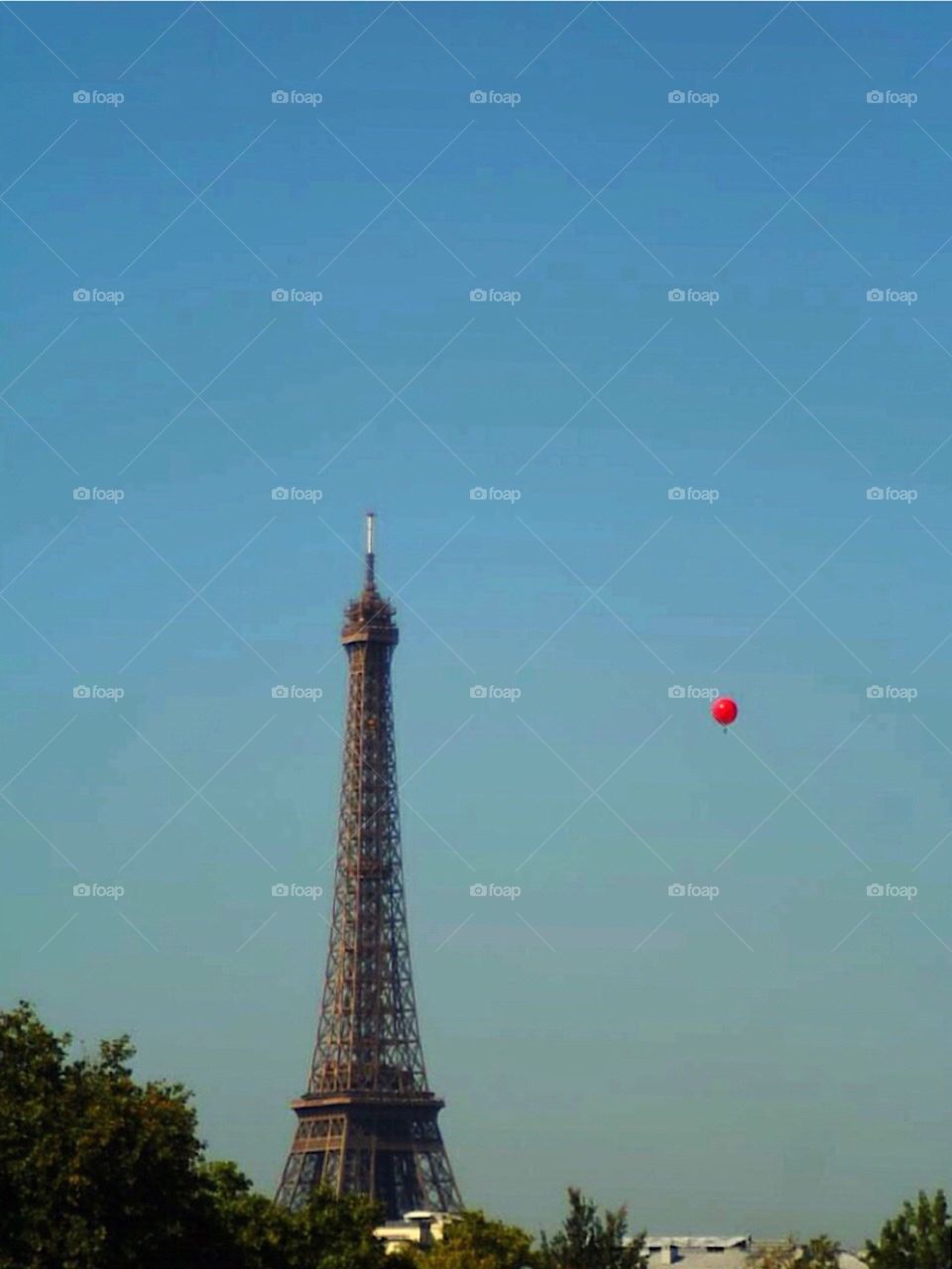 red balloon is flying over the Eiffel Tower in Paris 