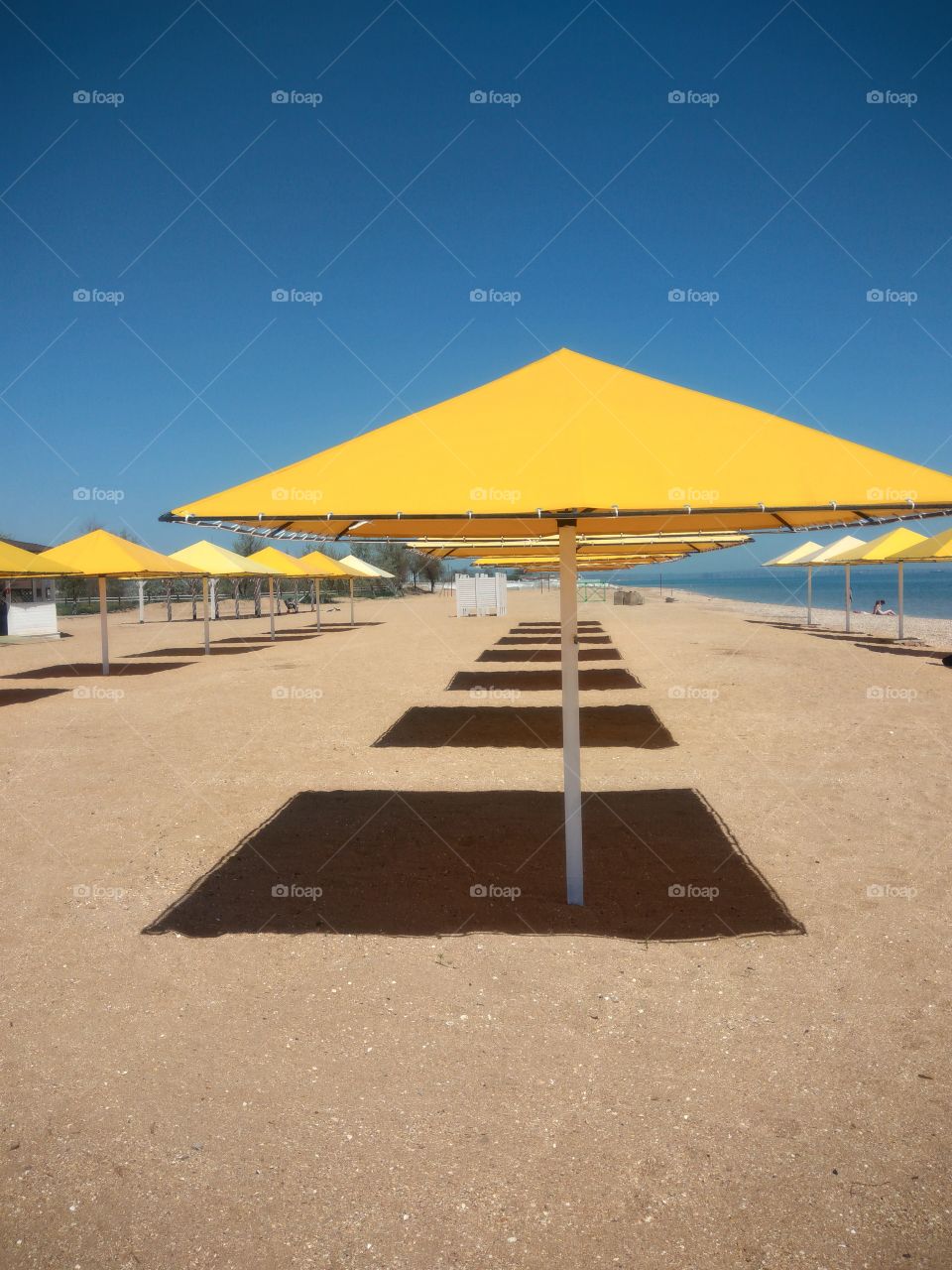 Sun umbrellas on sandy beach in summer