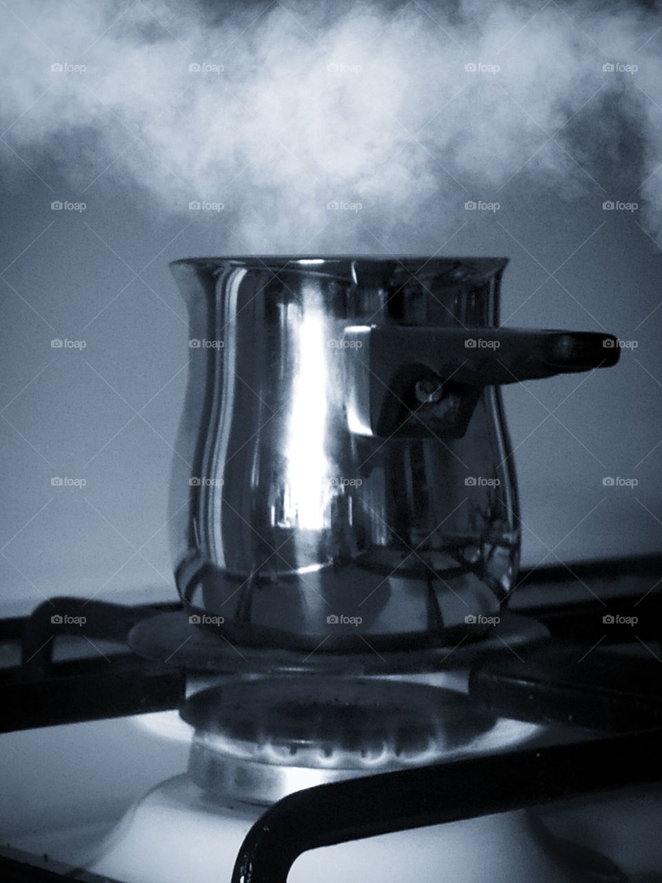 Metal coffee Turk stands on the gas stove. Couples highlighted from above