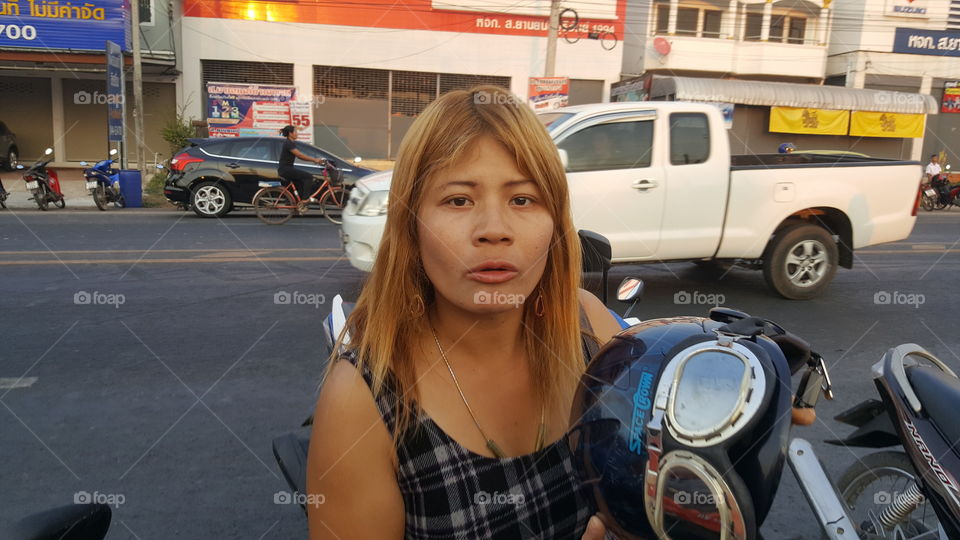 Thai woman waiting on her scooter