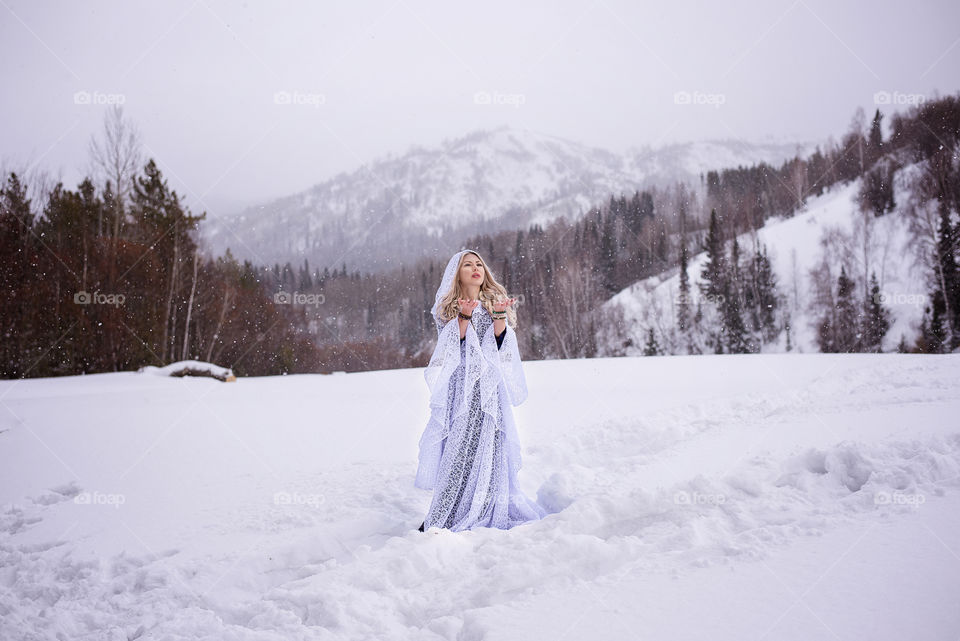 Pretty woman standing on snowy landscape
