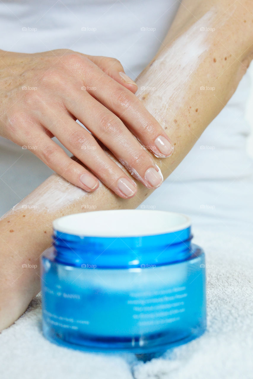applying body lotion to skin