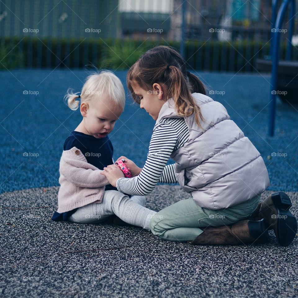 Sisterly love showing kindness by helping her sister out in her bracelet 