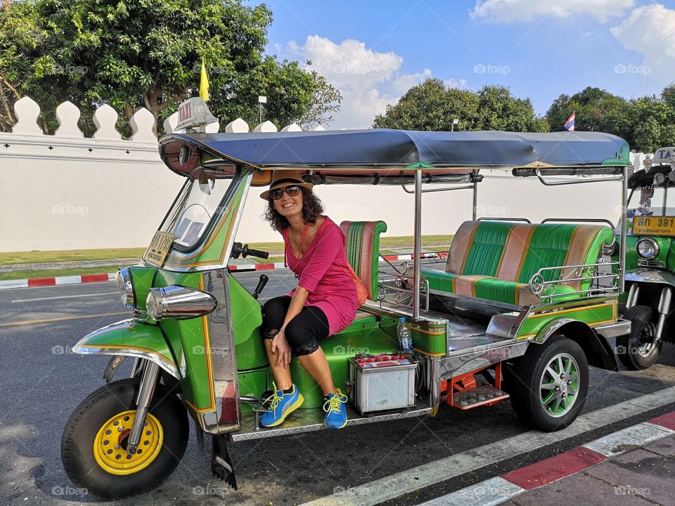 smiling woman on the tuc tuc on the streets of Bangkok