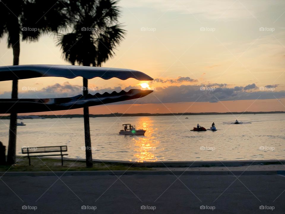 Sun From Sunset Seems To Be Grabbed By The BBQ Tongs At The Seashore On A Tropical Environment.