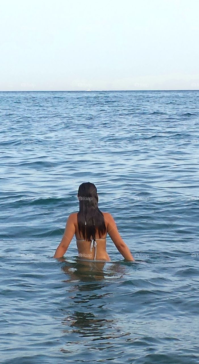 Chica dandose un baño en el mar
