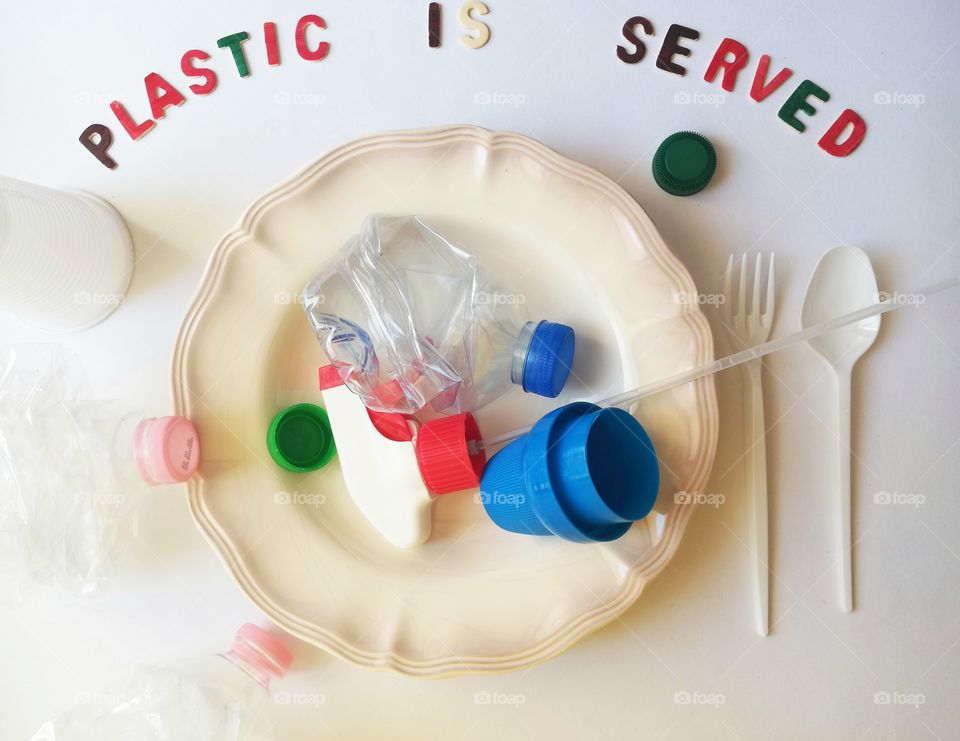 Flat lay with written plastic is served and plastic items