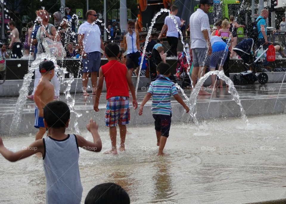 People cooling off in the fountains at Old Market Square in Nottingham, England