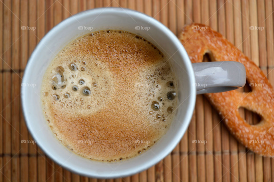 cup of coffee on a bamboo wooden background with biscuit cookie