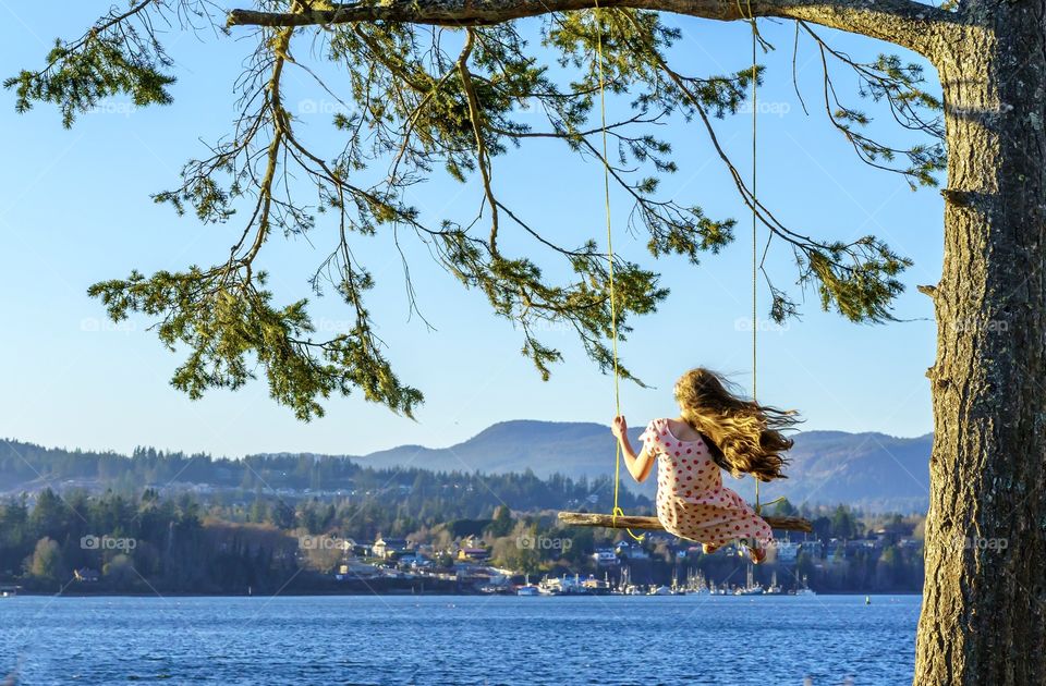 Girl swinging on a beautiful ocean shore
