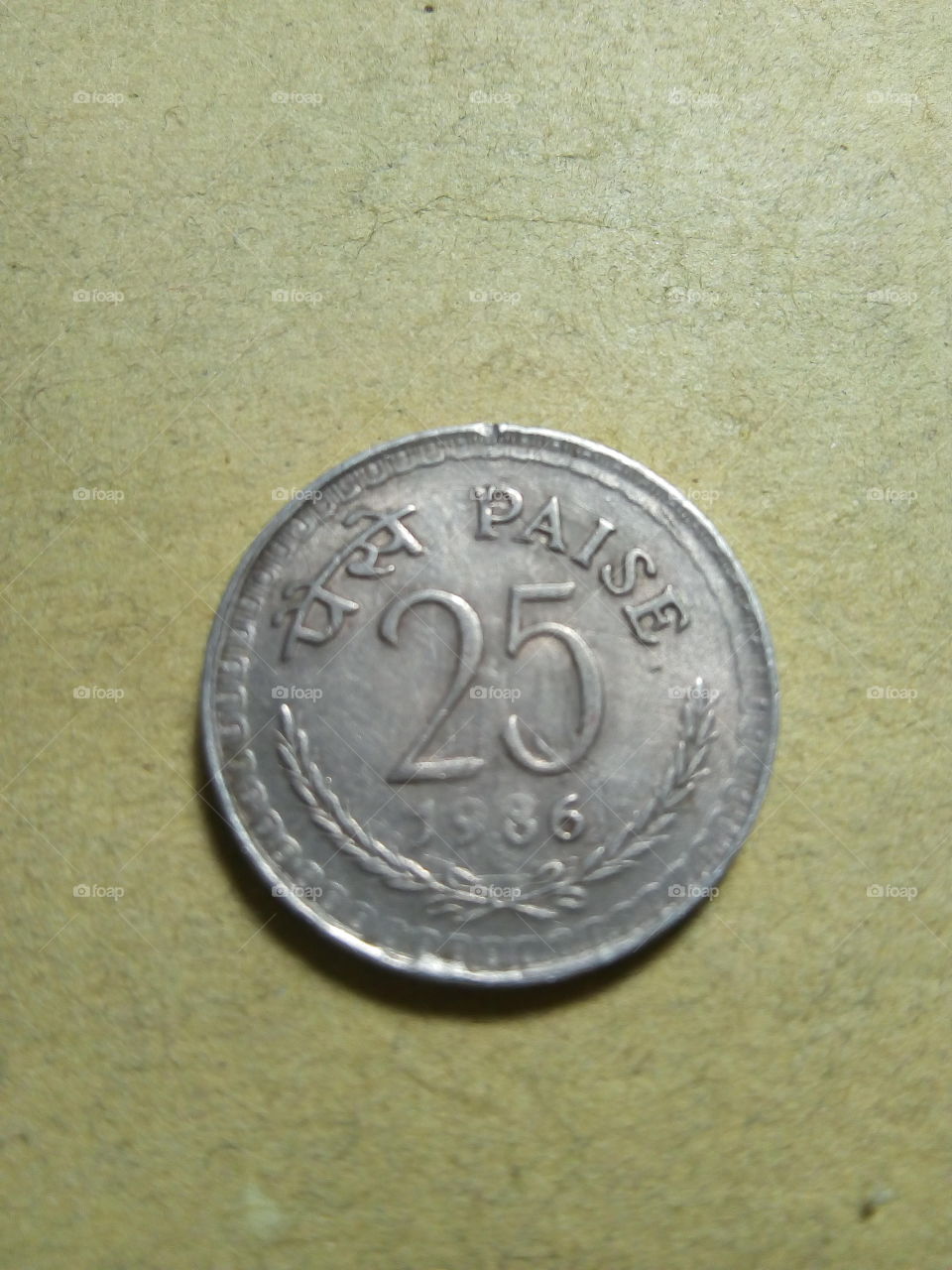 A coin of twenty five paise- 1/4 share of Indian Rupee issued by Government of India in 1986.