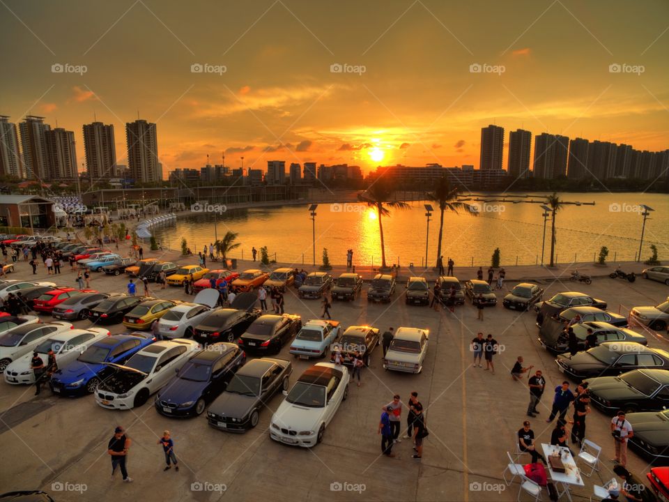 drone aerial view from above of bmw cars parked next to a lake