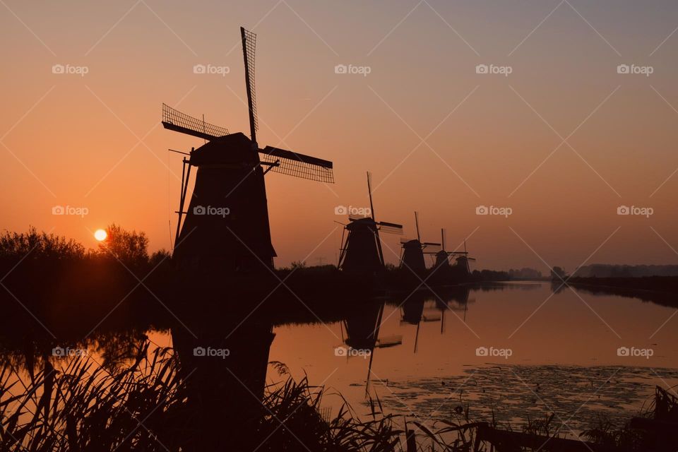 Diminishing perspective of windmills at sunrise. 