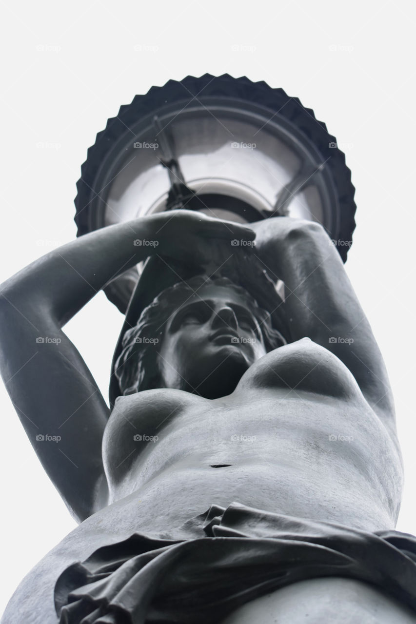 A woman statue holding a light

