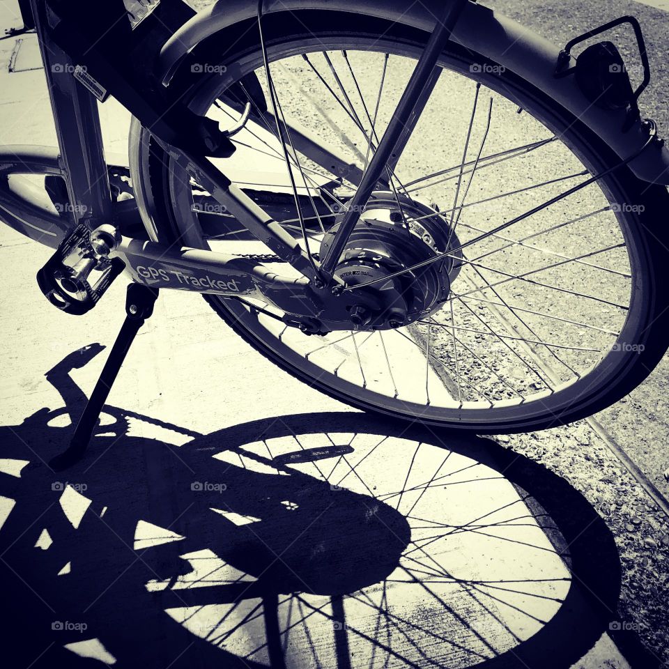 One lonely bicycle, shadow of a bike, black and white bike image, art on the street with bicycles, shadow of a bicycle 