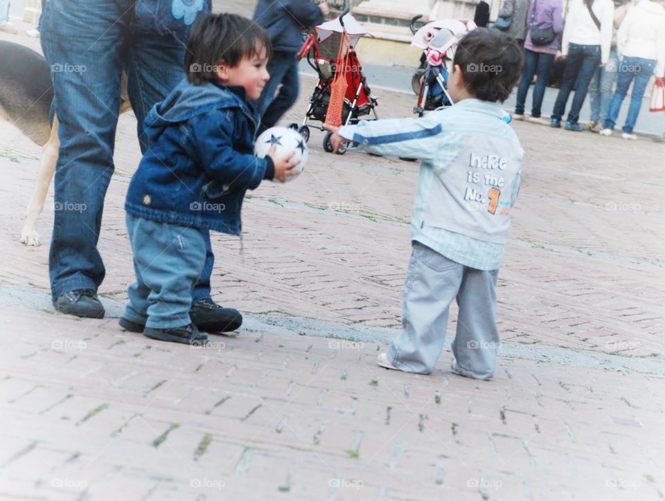 Tiny tots. Two toddler boys playing with a ball