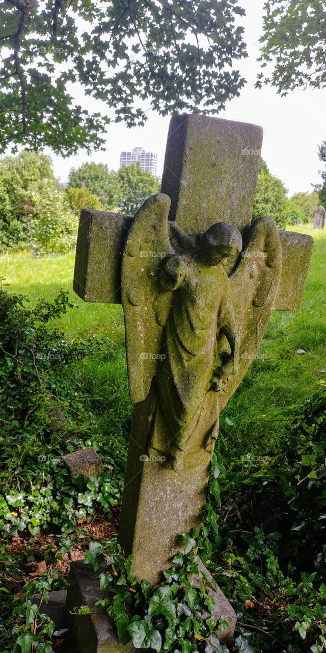 carved stone angel on grave cross
