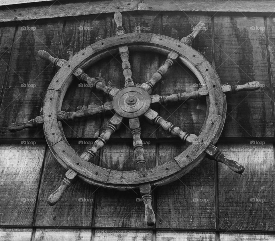 Ship steering wheel captured on wooden background