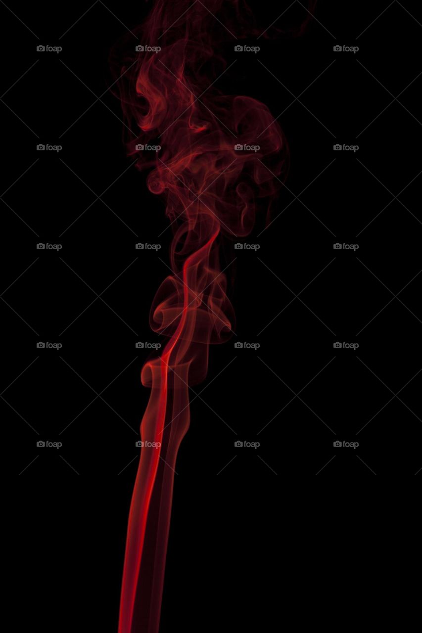 Red abstract smoke swirling on black background
