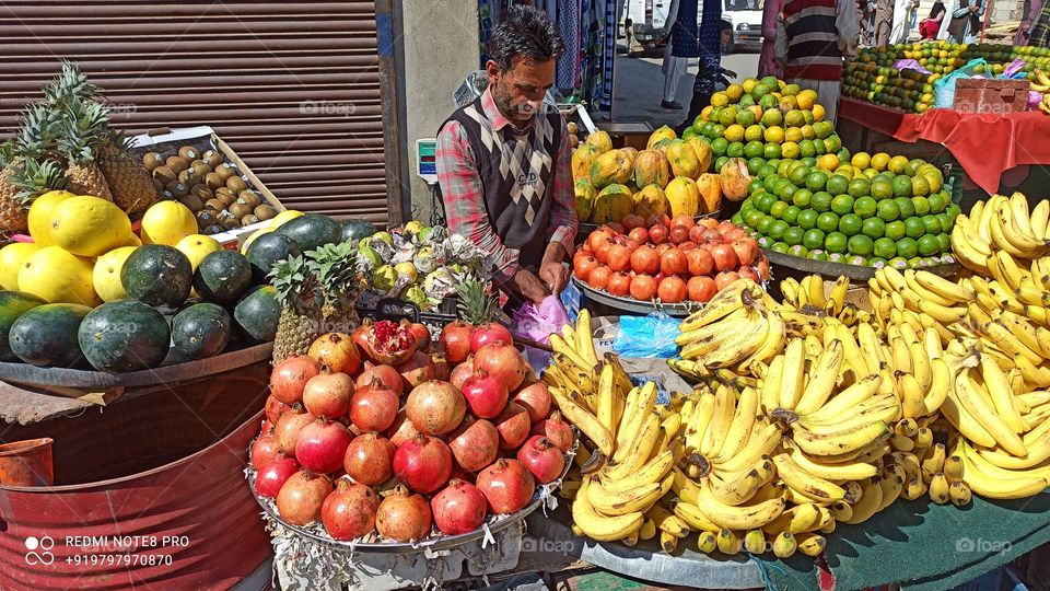 Friut  Vendor  having variety of Fresh Fruits by the side of a  busy  road in Srinagar  of Kashmir valley  J&K IND...