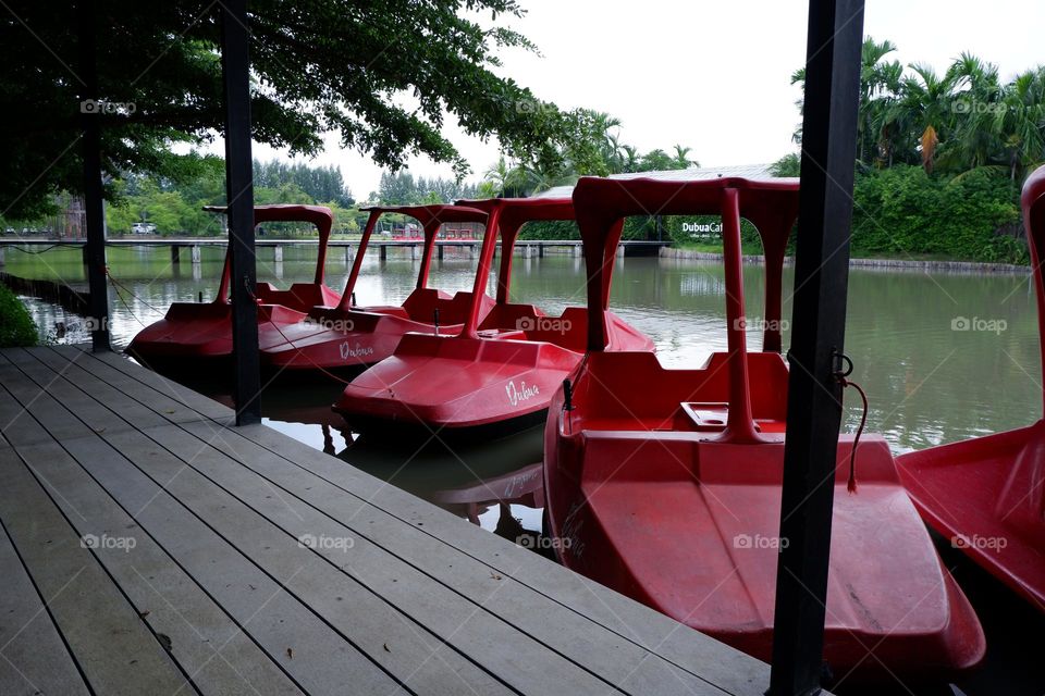 A boat that uses its legs to move in red floats on the water.