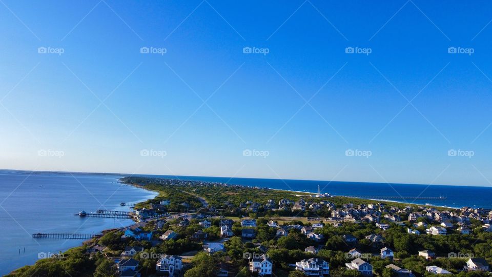 Unique birds eye view flying over Duck, NC with the beautiful ocean on the right and majestic sound on the left, and the beautiful homes throughout - taken by aerial pointe drone 
