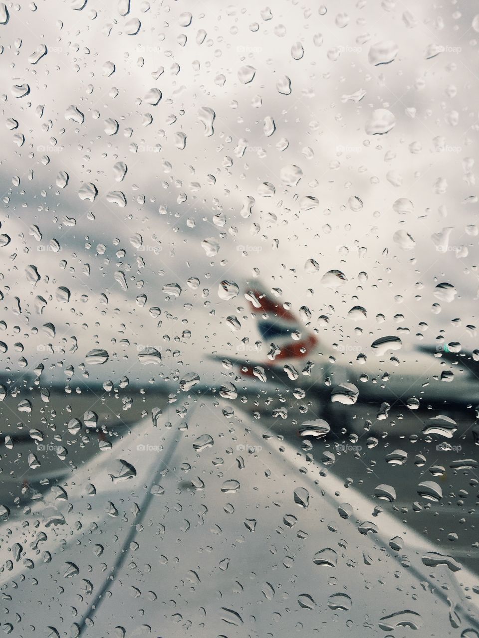 Rain drops on window in airplane. A picture taken on a rainy day in Heathrow 