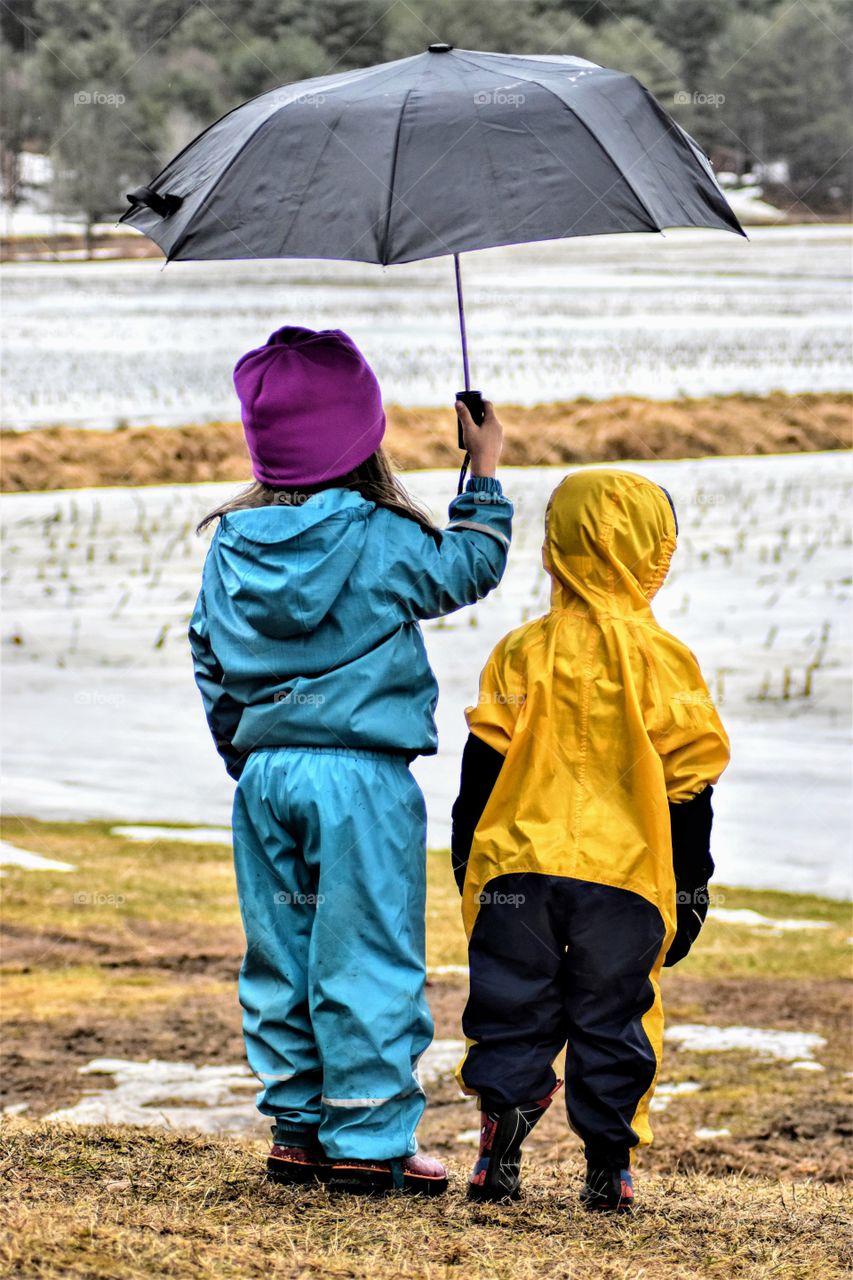 siblings outside in the rain