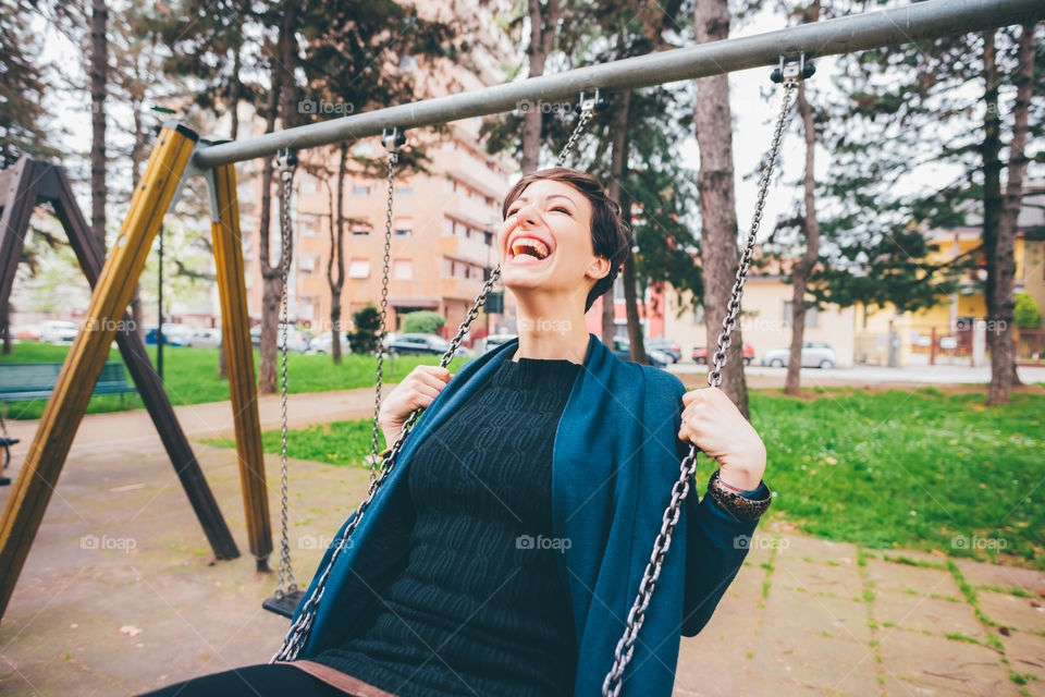Happy young woman playing at the park smiling - freedom, happiness, carefree
