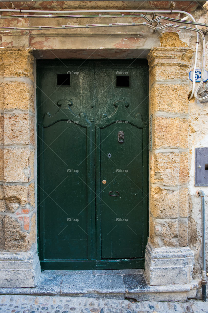 Old door in the city of Cefalu on Sicily.