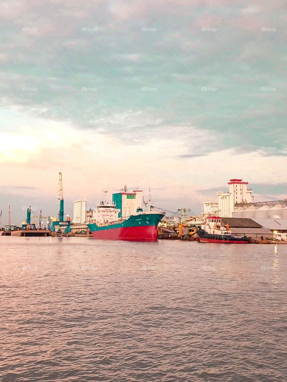 Portrait of a large red and blue ship docked in the harbor