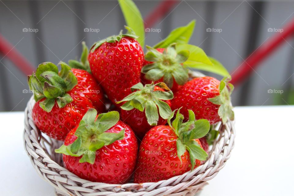 Close up of ripe organic strawberries in a white wicker basket